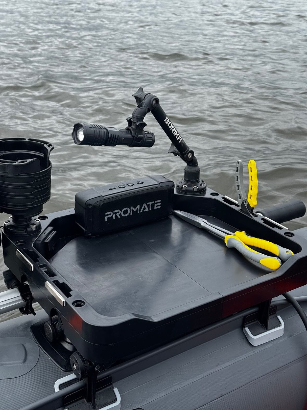Чорна платформа на човні з ліхтарем, плоскогубцями та тримачем над водою